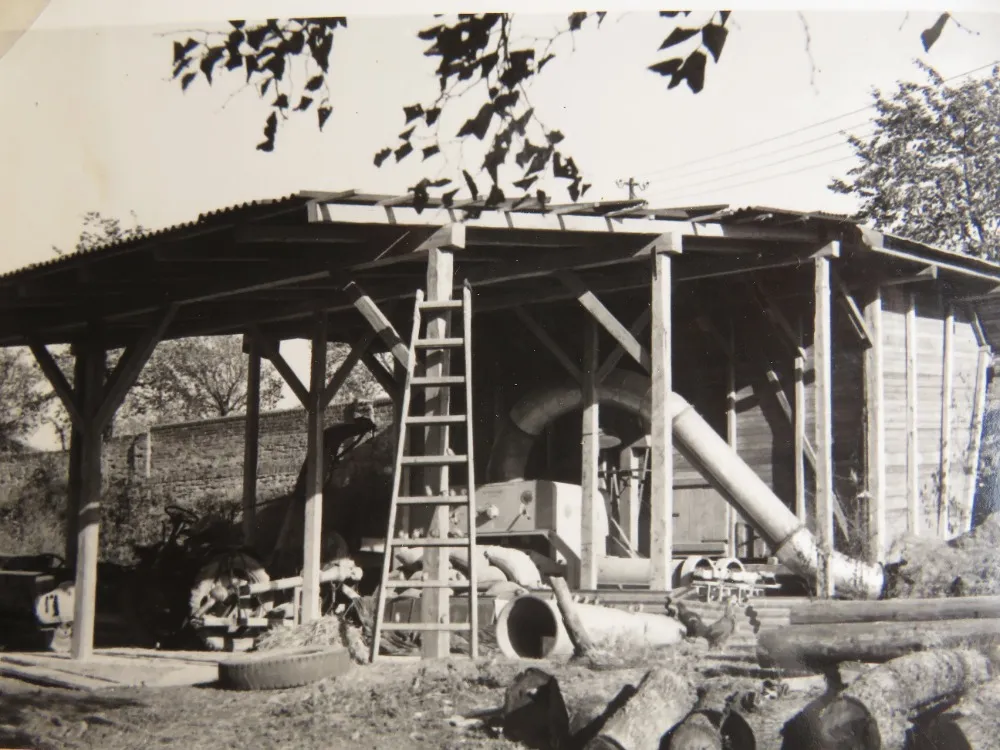 A threshing machine with a blower under its shelter.